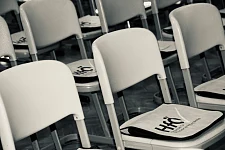 Das Bild zeigt Stühle mit Taschen, welche die Studierenden zur Begrüßung bekommen. 